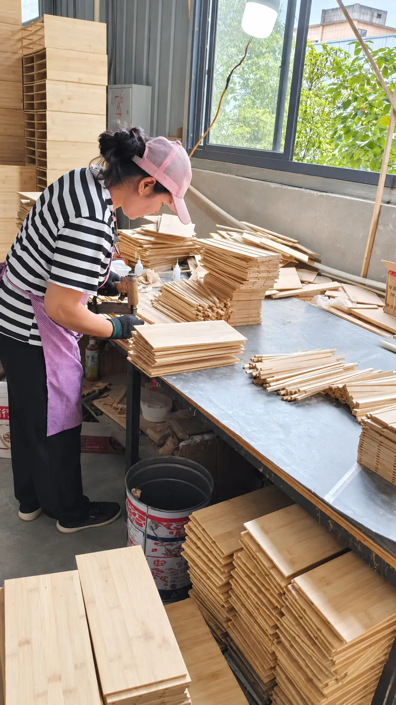 Bamboo box parts being assembled by hand at a workshop station